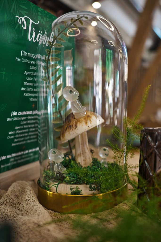 Detailshot if a Ghibli inspired figurine in front of a green menu card for beverages