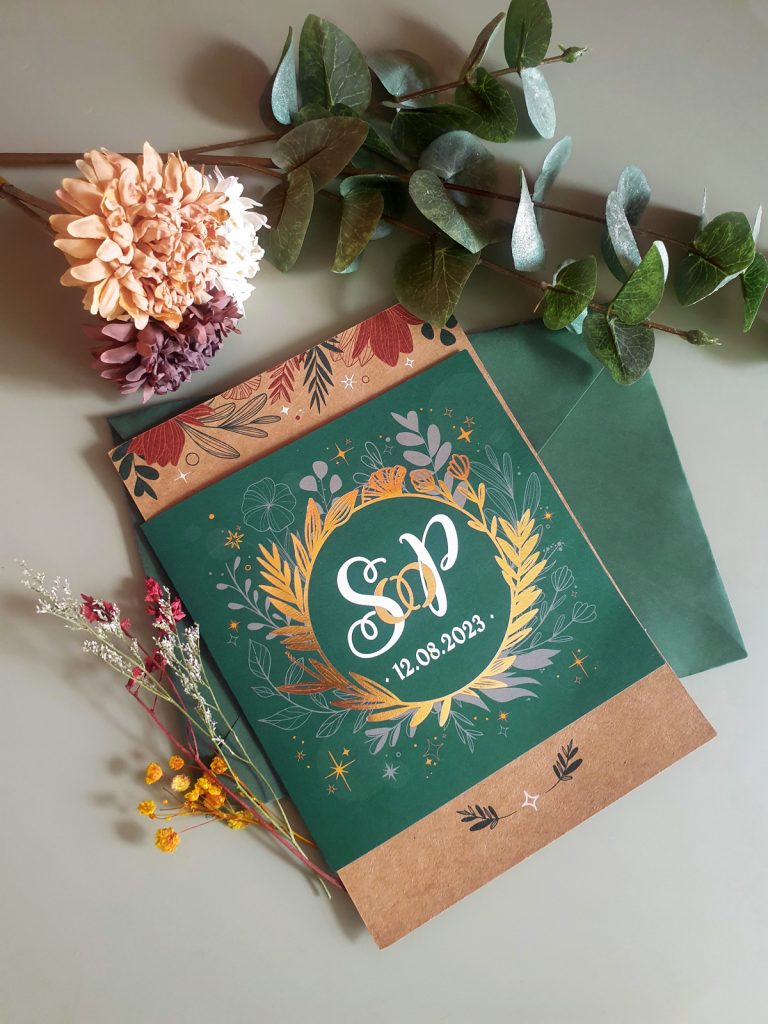 Wedding Invitation with golden and green details in front of a color matching envelope