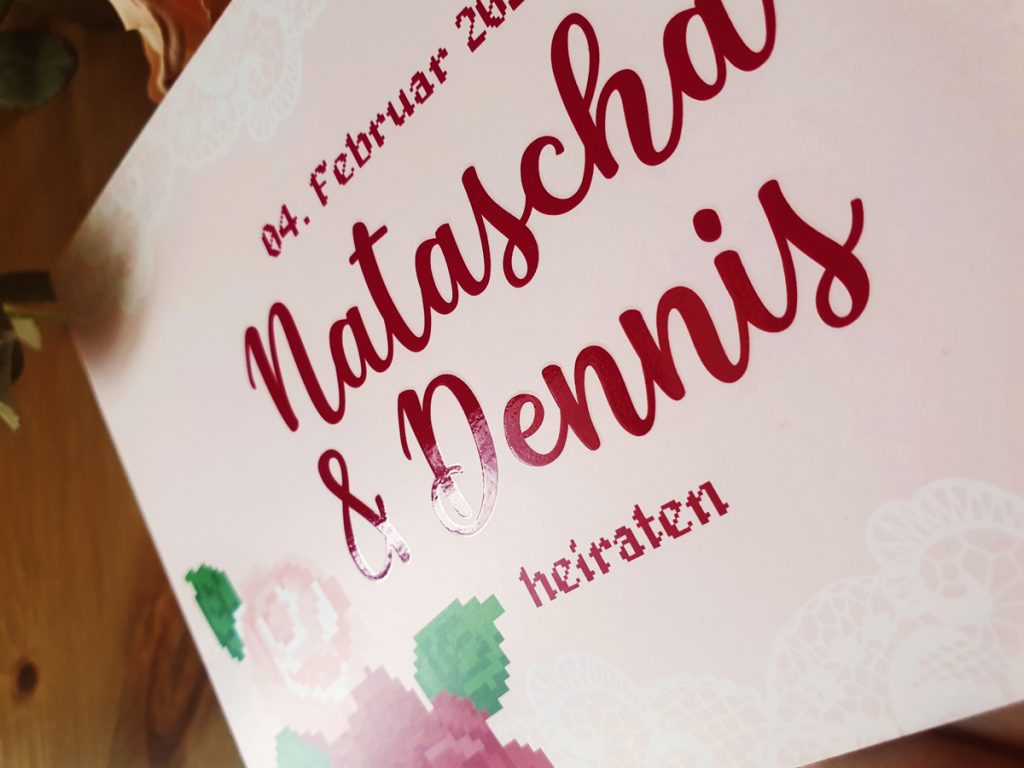 pink wedding invitation showcases the shiny finnisch on the card highlighting the names of the coupßle