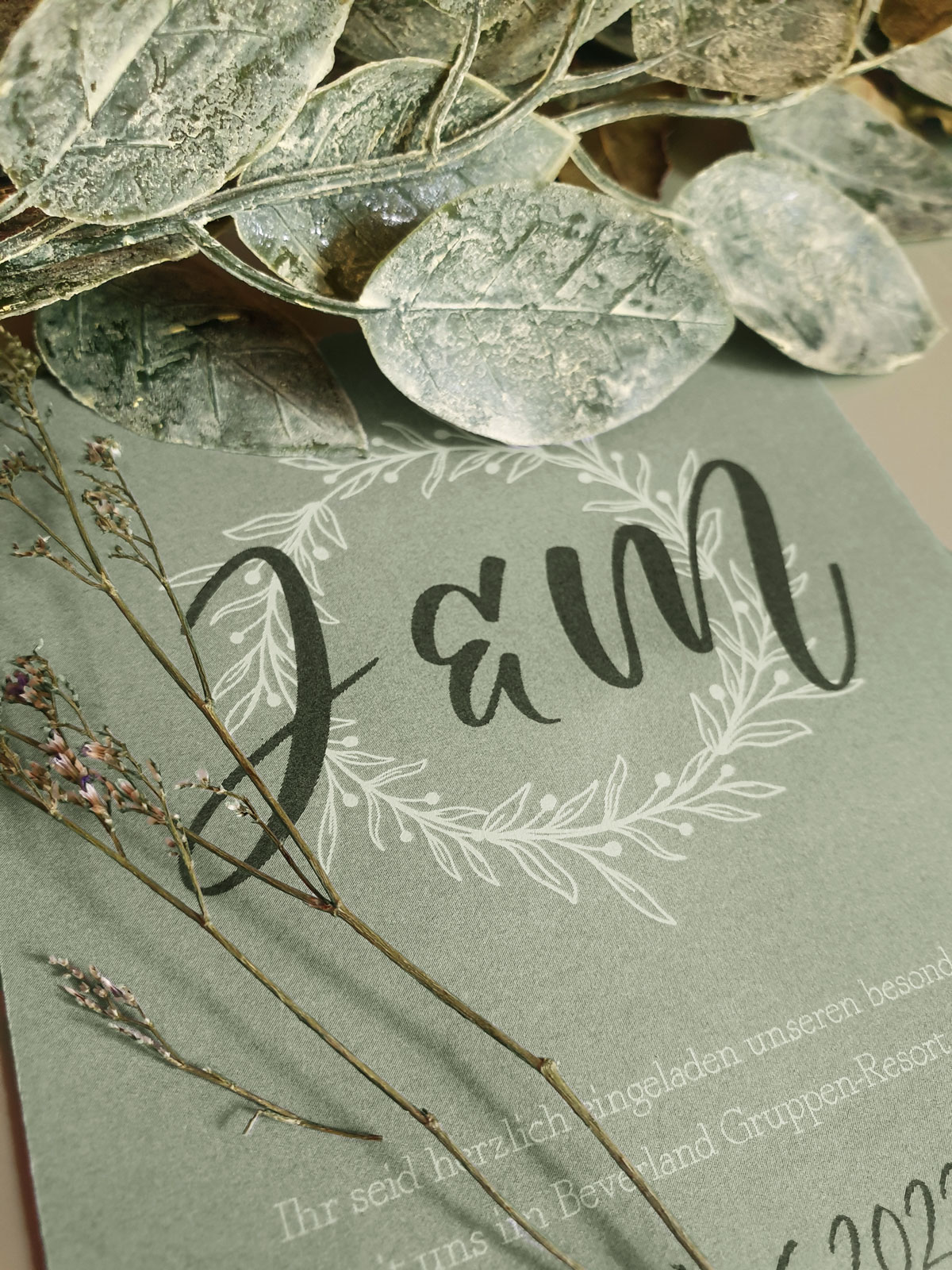 Wedding Logo of the initials J and M on a sage green wedding invitation